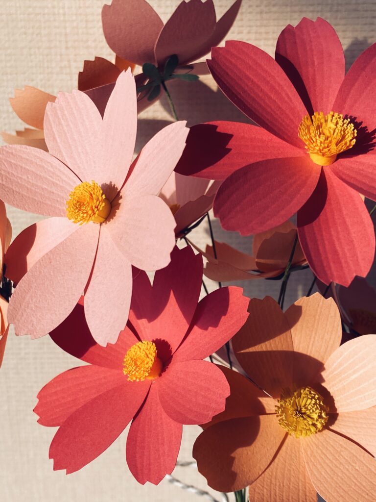 Close-up of a finished pink paper cosmos flower with a yellow center