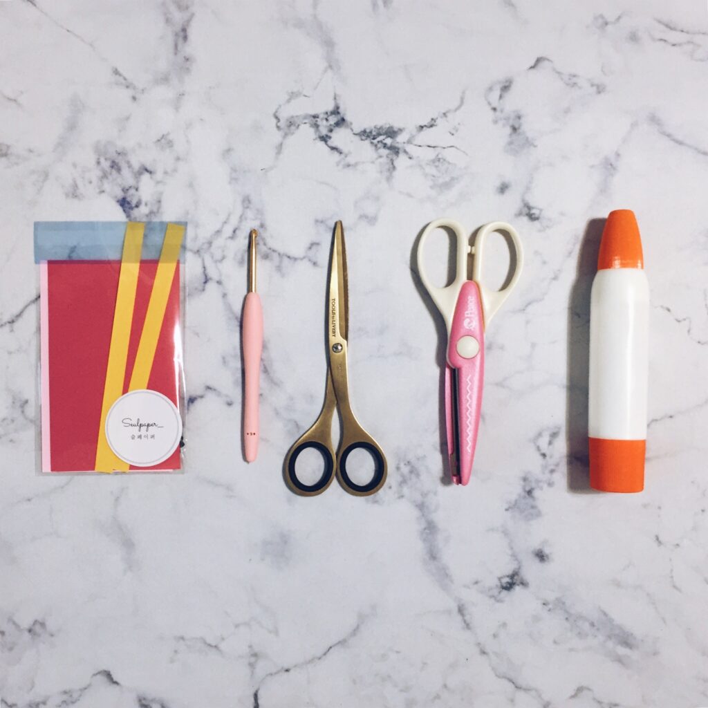Colored paper, scissors and basic tools prepared for making a paper cosmos flower