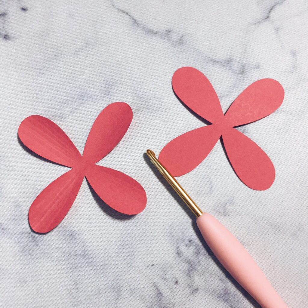 Shaping a pink paper cosmos petal with a hand tool